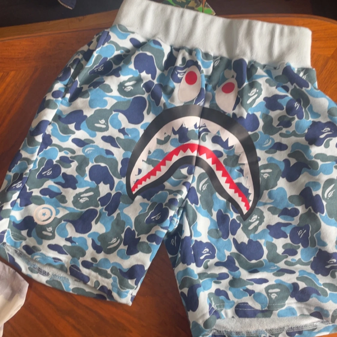 Blå camo-shorts med hajmotiv från BAPE