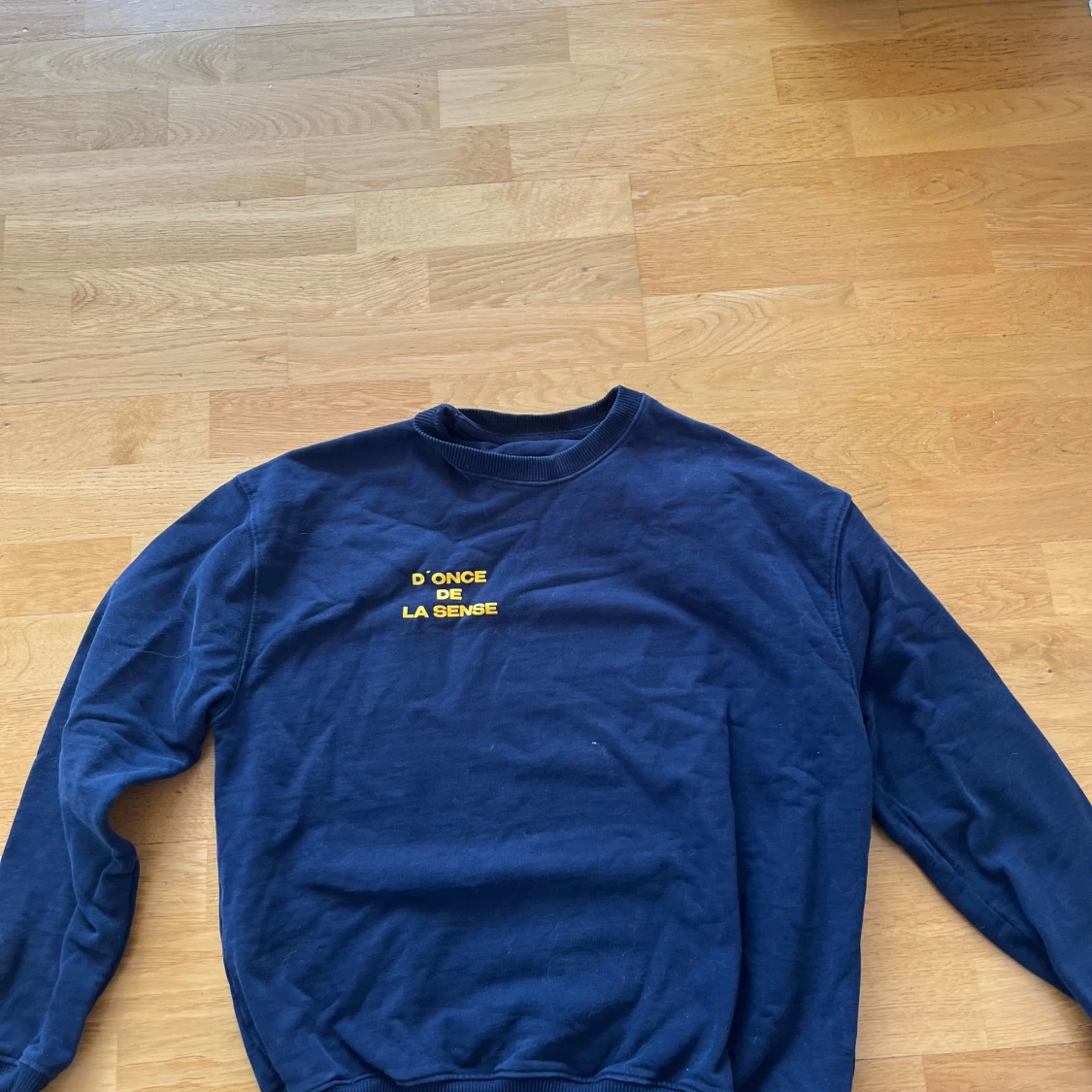 Mörkblå sweatshirt med gul text