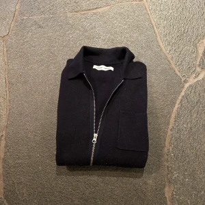 Mörkblå tröja med dragkedja från Samsøe Samsøe - Snygg mörkblå tröja från Samsøe Samsøe med dragkedja framtill och en bröstficka. Den är lite knoprig men själv tycker jag det är snyggare än när det är nyskick på denna snygga overshirten. Nypris: 1499    Mitt pris: 389