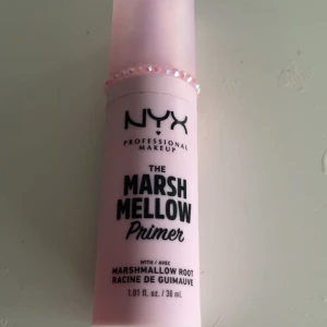 The Marsh Mellow Primer från NYX - Säljer en rosa primer från NYX Professional Makeup, The Marsh Mellow Primer. Innehåller marshmallowrot och kommer i en 28 ml flaska. Perfekt för att skapa en jämn bas för smink.