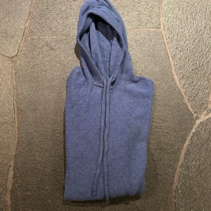 Blå hoodie - Säljer en snygg blå hoodie med dragsko i huvan. Perfekt för en avslappnad stil. Säljer för 150