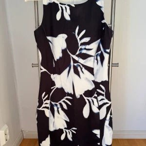 Svart, blå och vit mönstrad klänning från H&M! - Svart klänning med blått och vitt växt mönster från H&M i storlek S. klänningen har en dold dragkedja i ryggen och är endast använd 1 gång.