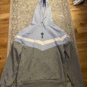 Grå och ljusblå hoodie med matchande byxor - Säljer nu min trapstar dress då den slutat komma till användning. Har använt den ungefär en sommar och den är i fint skick. Tröjan och byxorna är i storlek XL men passar som L/M priset går att diskutera vid snabb affär!