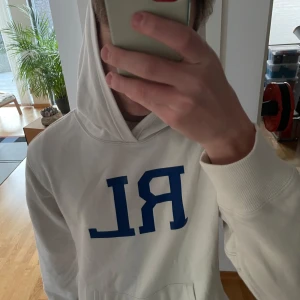 Ralph Lauren Hoodie - Säljer en unik vit hoodie från Ralph Lauren. Hoodien är i väldigt bra skick även fodret inuti är fortfarande mjukt och fluffigt. Sjukt trendig just nu och sitter i strl M men passar även S. Hör gärna av er vid frågor eller funderingar!!
