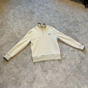  Fred Perry halv zip  - Säljer en stilren tröja från Fred Perry med halv dragkedja och broderad logga på bröstet. Tröjan är helt oanvänd och därför i 10/10 skick , Nypris 1800kr i butik