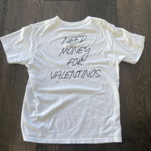 Gurkis - Limited T-Shirt - Säljer en vit t-shirt med texten 'NEED MONEY FOR VALENTINOS' tryckt på baksidan. T-shirten har en klassisk passform och är kortärmad. Använd max 3 gånger.