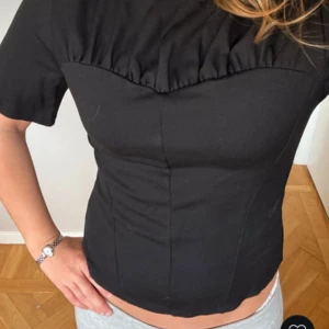 Svart korsettliknande topp - Snygg svart topp med korsettliknande design och korta ärmar. Säljer då den var lite stor på mig, storlek s, (lånad bild)