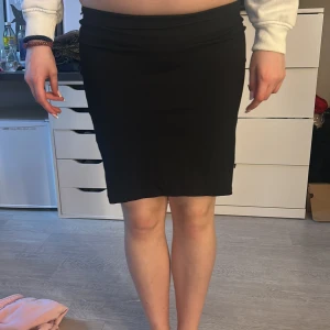 Svart kjol från Gina Tricot - Säljer en stilren svart kjol från Gina Tricot i storlek M. Kjolen har en tight passform och är perfekt för en chic look. Den är enkel och mångsidig, vilket gör den lätt att matcha med olika toppar.