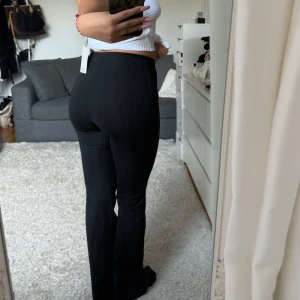 Svarta bootcut byxor, kostym - Snygga svarta bootcut byxor med medel midja. Perfekta för en stilren look och passar till många olika toppar. Byxorna har en smickrande passform och är både bekväma och trendiga.