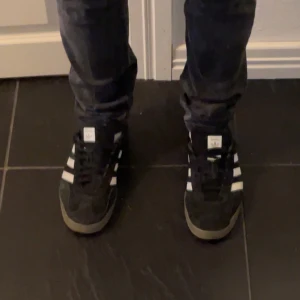 Svarta Adidas Gazelle sneakers - GE ETT PRISFÖRSLAG SÅ KANSKE JAG GODKÄNNER . Säljer ett par klassiska svarta Adidas Gazelle sneakers, dom har aldrig blivit använda utomhus men legat inte tryckt i en låda så dom har några defekter (finns på sista bilden) 