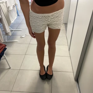Vita spets shorts - Snygga vita shorts med spetsdetaljer, perfekta för sommardagar. De har använts en del, så fina! 