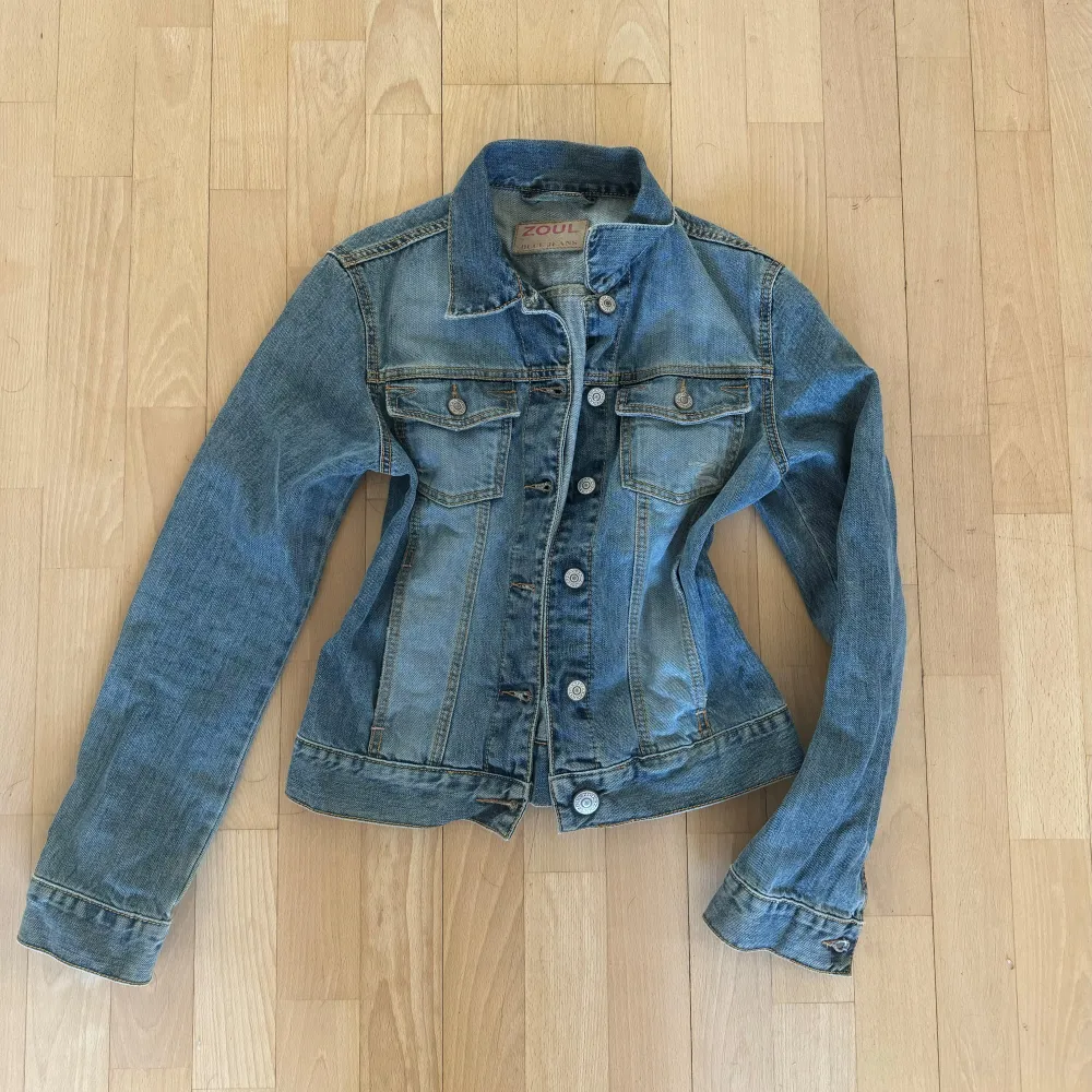 Snygg blå jeansjacka från Zoul. Jackan har långa ärmar och knappar framtill samt två bröstfickor. Storlek S Passar mig som är 164cm . Takit.