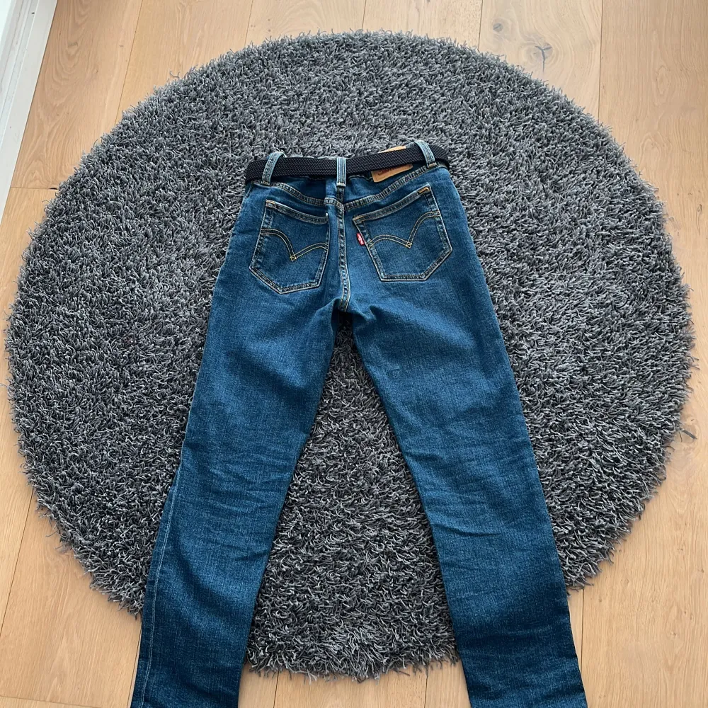 Snygga blå jeans med klassisk femficksdesign och ett stilrent bälte. Perfekta för en avslappnad look. Passar bra till både sneakers och kängor.. Farkut & Housut.