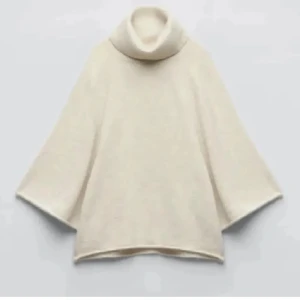 Trendig zara "poncho" - Säljer en stilren beige polotröja med en lös passform. Tröjan har en hög polokrage och vida ärmar, perfekt för en avslappnad look. Materialet är mjukt och bekvämt.