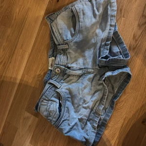 Lågmidjade Ljusblå jeansshorts - Säljer ett par lågmidjade jeansshorts. Skit snygga! Lite insydda i midjan- midjemått 36!. Säljer då dom inte används tyvärr
