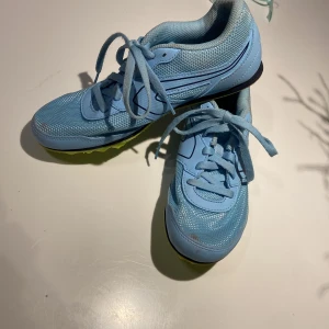 Ljusblå spikskor i mycket gott skick  - Säljer ett par ljusblå spikskor från AT Start. Kan användas för friidrott både sprint och långdistans. Skorna är använda max 5 ggr.