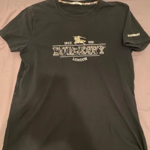  t-shirt Burberry - Snygg svart t-shirt från Burberry med broderad logga på bröstet och ärmen. Har haft den i ett tag men den är i väldigt bra kvalitet.