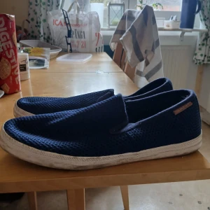 Blå loafers från Gant - Säljer ett par stilrena blå loafers från Gant. Skorna har en luftig mesh-design och en vit sula som ger en sportig känsla. Perfekta för en avslappnad stil.