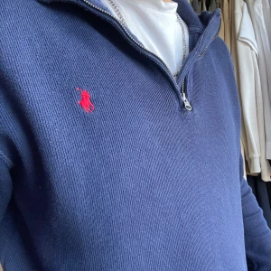 Ralph lauren zip  - Snygg blå tröja från Ralph Lauren med halv dragkedja och röd logga på bröstet. I storlek S 
