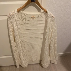 Vit stickad kofta från Holly & Whyte - Säljer en stilren vit stickad kofta från Holly & Whyte by Lindex. Koftan har ett luftigt stickat mönster och långa ärmar, perfekt för lager-på-lager under kyliga dagar. Den är både bekväm och snygg, ett måste i garderoben! 🤍