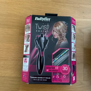 BaByliss Twist Secret Starter Kit - BaByliss Twist Secret är ett elektriskt hårstylingverktyg för att enkelt skapa tvinnade frisyrer. Kitet innehåller maskinen i svart och rosa samt flera accessoarer som hårband, snoddar och dekorationer i olika färger och mönster.