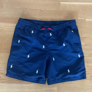Marinblå shorts från Polo Ralph Lauren - Säljer mina marinblåa Ralph lauren badbyxor. Storlek Y(14-16) vilket betyder ungefär xs