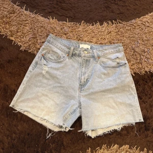 Ljusblå jeansshorts från H&M - Säljer ett par ljusblå jeansshorts som har använts bara 1 gång samt köptes för 229kr men säljs för 100kr. Dom är i helt bra och ny skick samt är dom i storlek 38.
