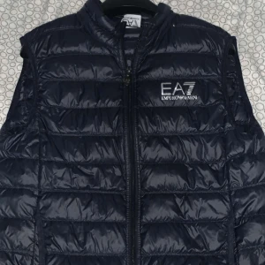 EA7 Väst - Säljer min EA7 väst som är perfekt för våren och sommaren. Västen är i nästan Nyskick o har få tecken på användning. Ordpris 1500kr. Är storlek L men sitter som M