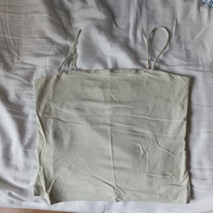 Ljus mintgrön linnetopp - Säljer en enkel och stilren mintgrön linnetopp med smala axelband. Toppen är slät i tyget och har en rak passform, perfekt att matcha med jeans eller kjol.