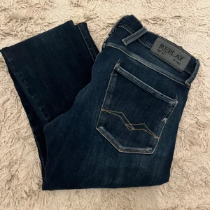  Replay jeans  - Säljer ett par mörkblå jeans från Replay med snygga slitningar. Modellen är anbass Dom är i riktigt fint skick storlek W28 L30