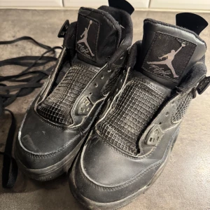Air Jordan 4 Retro “Black Cat”  - Rengör dem även inan jag postar dem.                                    Säljer ett par svarta Nike Air Jordans sneakers med klassisk Jumpman-logga på plös, häl och sula. Skorna har nätpaneler på sidorna, snörning och platt sula. Perfekta för dig som gillar streetwear och vill ha en ikonisk look.