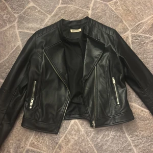 Svart skinnjacka från H&M - Säljer en svart skinnjacka från H&M, använd men ändå väldigt fin och den är i bra skick. Passar till allt men inte min stil längre