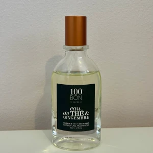100BON Eau de Thé & Gingembre parfym - Fräsch parfym från 100BON med doft av te och ingefära. Flaskan är genomskinlig med en stilren brun kork och en mörkgrön etikett. Innehåller 50 ml och är tillverkad av naturliga ingredienser. Använd endast två gånger