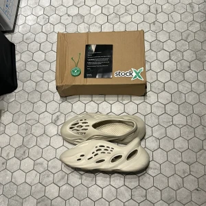 Adidas Yeezy Foam Runner - Säljer ett par Adidas Yeezy Foam Runner i beige. Skorna har en futuristisk design med många hål och är tillverkade i syntetmaterial. Perfekta för dig som vill sticka ut med en unik och bekväm sko. Priset är inte hugget i sten och är öppen för byten mot allt möjligt bara att skriva om du har fler frågor. Storleken är Us 11 men passar 44 eu perfekt