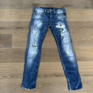Blå slitna jeansbyxor från Replay Anbass - Säljer ett par blå replay Anbass jeans med snygga slitningar. De har normal passform och är tillverkade i jeansmaterial. Perfekta för dig som gillar den mer populära och trendiga stilen. Pris kan diskuteras vid snabb affär💫