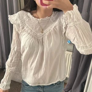 Vit blus med spetsdetaljer - Säljer en romantisk vit blus med spetsdetaljer och volang vid axlarna. storlek s från only