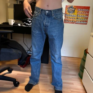 Blå raka jeans  - Klassiska blå jeans med rak passform och normal midja. Jeansen har 4 fickor och stängs med  knappar. Perfekta för en avslappnad stil och funkar året runt. 28/32 passform. Lite slitna längst ner, syns knappt