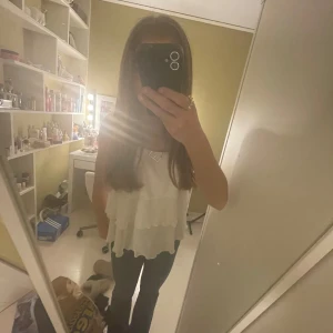 Vit volangig linnetopp - Säljer en vit linne blus med  volanger och tunna axelband. Toppen har en luftig och flowy passform, perfekt för varma dagar. Enkel att matcha med både jeans och kjol. Använd fåtal gånger men är i mycket fint skick. Är i st.164 men passar perfekt för mig som vuxen i XS.