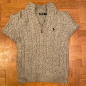 Grå kabelstickad halv zip från Polo Ralph Lauren - Säljer en grå kabelstickad tröja från Polo Ralph Lauren med halv dragkedja och kort ärm. Tröjan är väldigt bekväm och har en jätte skön avslappnad fit, den är i Nyskick bara testad aldrig andvänt har också polo taggen kvar. fick den som present i jul men nu säljer vidare den. Det finns ett digitalt kvitto. Priset går att diskuteras vid snabb äffär. Vid frågor är det bara att fråga:)