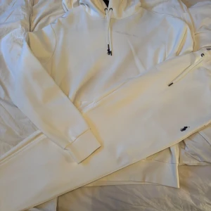 Vita mjukisbyxor från Ralph Lauren - Fläck på som tillkommit i flytten, aldrig tvättat setet eller använt det. Setet är helt nytt och nypris är 4000 . Säljer ett par stilrena vita mjukisbyxor från Ralph Lauren med klassisk broderad logga vid fickan. Byxorna har dragsko i midjan och är perfekta för en avslappnad look.