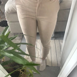 Beiga kostymbyxor från H&M - Säljer ett par beiga kostymbyxor från H&M (en äldre modell). Byxorna har tight passform och hög midja. De har resor i midjan, vilket gör att de passar de flesta. Säljer på grund av att de aldrig använts. Priset går att diskuteras vid snabb affär 💌
