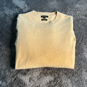 Beige cashmeretröja från Massimo Dutti - Säljer en riktigt fin beige kashmirtröja från Massimo Dutti. Tröjan har en rund halsringning och långa ärmar med ribbade muddar. Perfekt för en stilren och bekväm look. Tillverkad i 100% kashmir för en lyxig känsla. Nypris ligger runt 2800 men jag säljer den billigare eftersom det finns en lagning på tröjans nedre kant som du ser på bild 4. Storlek s men passar fint på Xs också.