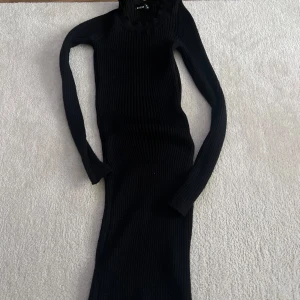Svart ribbad kort klänning med polokrage - Säljer en svart ribbad kortklänning med lång ärm och polokrage. Klänningen är egentligen väldigt stretchig och har en stilren look som passar perfekt till kyligare dagar. Enkel att styla med boots eller sneakers.