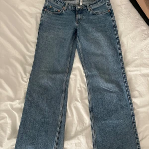 Blå Weekday Arrow Low Jeans  - Säljer ett par blåa lågmidjade jeans från Weekday. De har en liten fläck/missfärgning vid ena benet längst ner som man kan se på sista bilden. 
