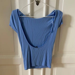 Ljusblå topp med öppen rygg - Sälher en jättefin topp med öppen rygg från Gina tricot. Den åker inte med för axlarna eller något och är i jättefint skick. Säljer super billigt så jag vill bli av med allt jag lagt upp så kika gärna in de!