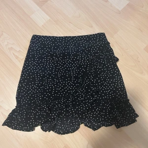 Prickiga volangkjolar 2st  - Supersöta prickiga kjolar i både vitt och svart, säljer båda för 50kr pga båda är för små för mig. Passar perfekt till sommar och går att styla lätt!