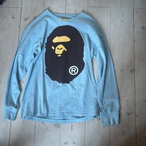 Ljusblå långärmad tröja från BAPE - Säljer min ljusblåa tröja från BAPE pga att jag tyvärr växt ur den. Den har inga defekter och är använd ett fåtal gånger. Passar till 150-160 cm lång.