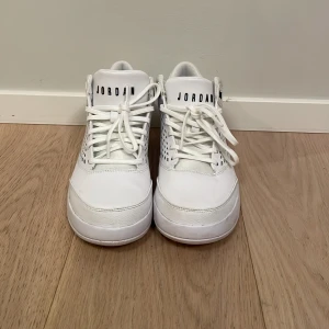 Vita Nike Air Jordans. Storlek 42,5 - Säljer ett par stilrena vita Nike Jordan Flight Origin 4 White Men's Shoes Basket med snörning och perforerade detaljer på sidorna. Skorna har en klassisk design med märkets logga på hälen och tungan. Perfekta för dig som vill ha en tidlös sneakerstil.