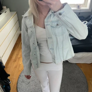 Ljusblå jeansjacka, denimjacka - Jättesnygg ljusblå jeansjacka perfekt nu till våren och sommaren😍Jackan är klippt då den har väldigt lång så fickorna fungerar inte, den har även två fläckar men som enkelt går bort i tvätten (har ej tvättat den därav priset). Annars är den helt felfri och använd endast en gång