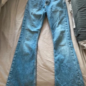 Blå bootcut jeans - Snygga blå bootcut jeans från TP. De har en klassisk femficksdesign och är perfekta för en avslappnad stil. Jeansen har en dragkedja och knapp framtill.